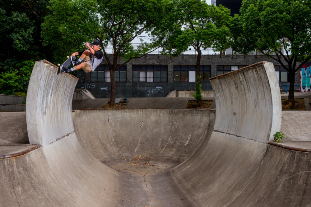 While the concrete crumbles and the coping rusts from acid rain, Tristan Rennie tail grabs a frontside nosepick at the desolate SMP Skatepark in Shanghai, China. - September 2017 Bryce Kanights